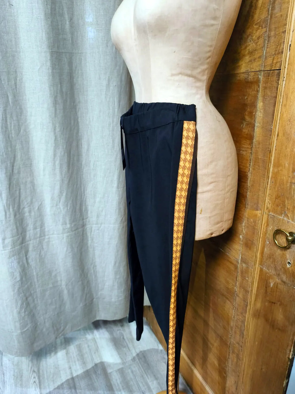 Pantalone in tessuto tecnico, modello dritto con banda colorata solo su un lato, spacchetto sul fondo, elastico in vita